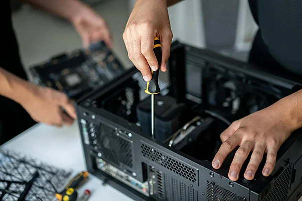 Técnicos realizando manutenção interna em computador desktop